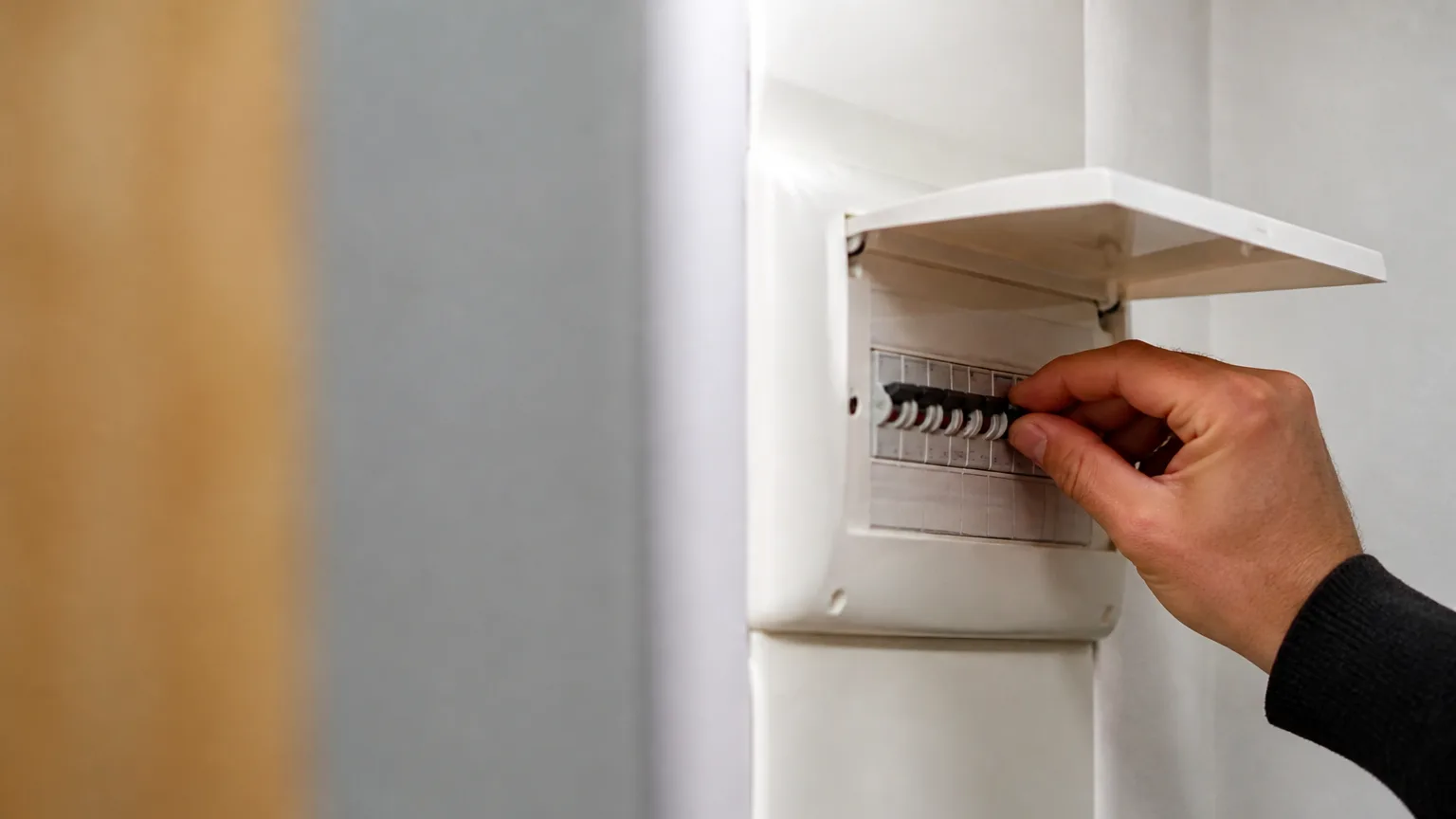Compteur électrique mural avec main ouvrant un disjoncteur