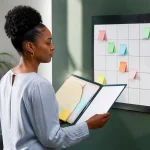 Personne tenant dossier ouvert face calendrier mural