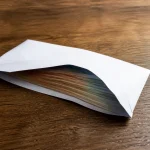Enveloppe de billets posee sur une table en bois