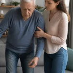 Fille soutenant son pere age dans le salon