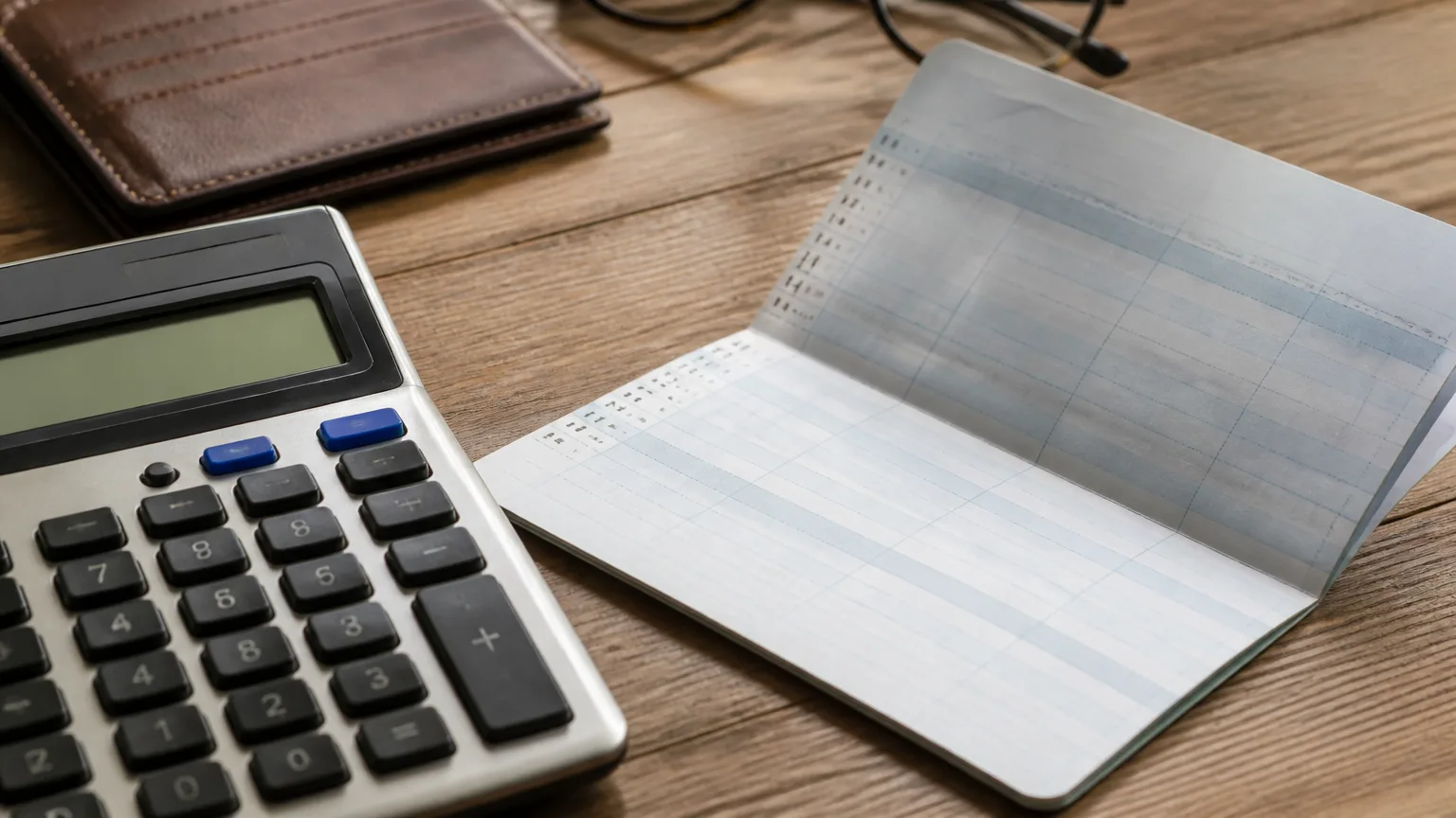 Homme age assis devant calculatrice et releve bancaire ouvert