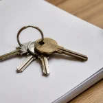Main tenant trousseau de cles sur dossier papier