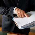 Notaire debout pointant une page de dossier de succession