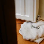 Plombier agenouille purge un radiateur avec une cle