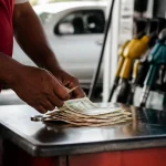 Pompe à essence avec billets posés sur le comptoir