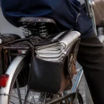 Deux seniors a velo, sacoches pleines de journaux