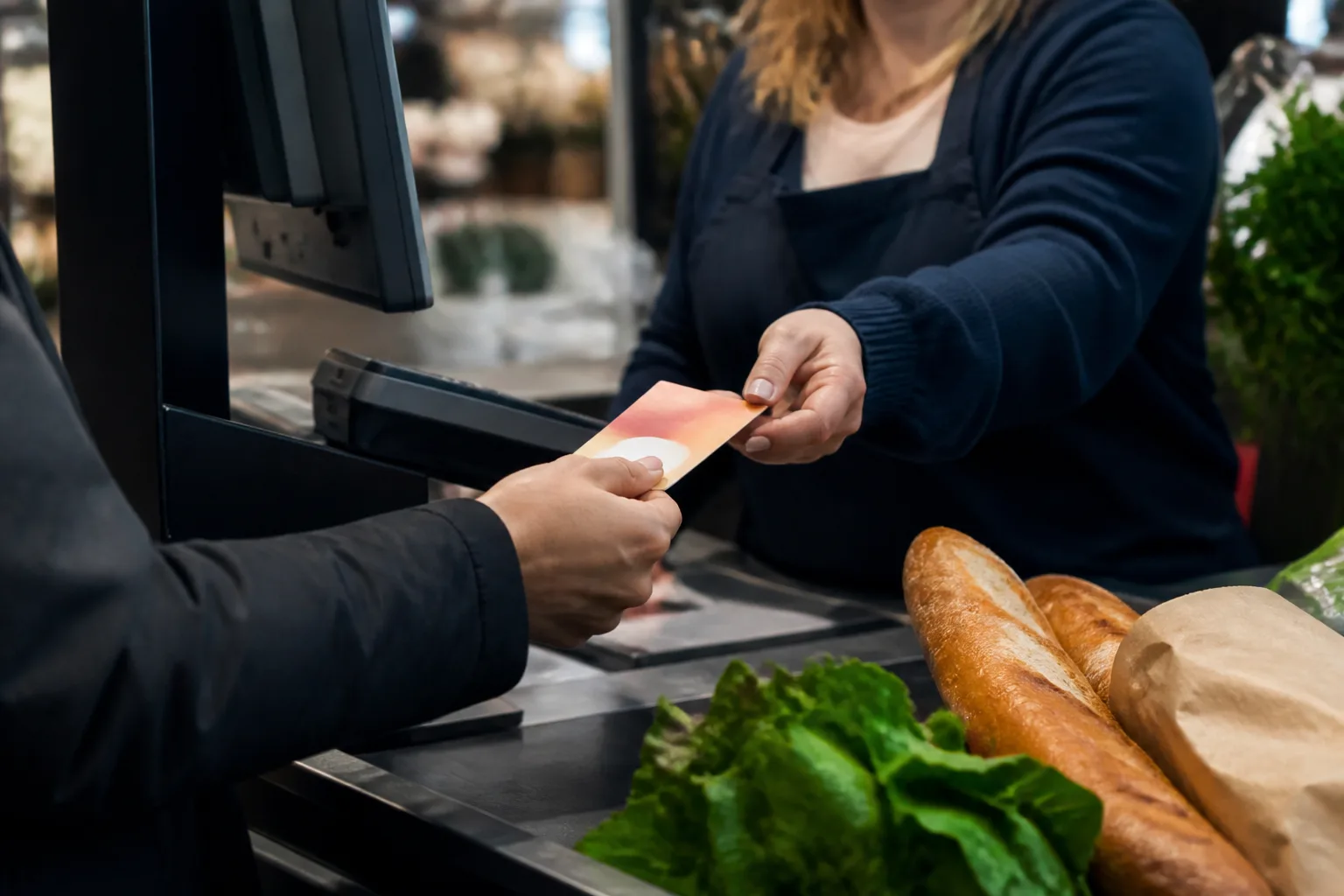 Ticket restaurant tendu a la caisse d'un supermarche