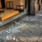 Vitrine de magasin brisee, verre disperse sur le trottoir